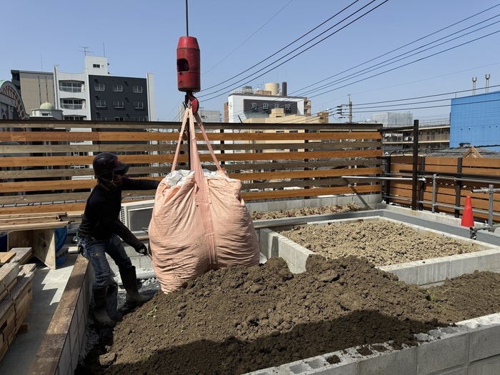 屋上へクレーンで土を入れているところ
