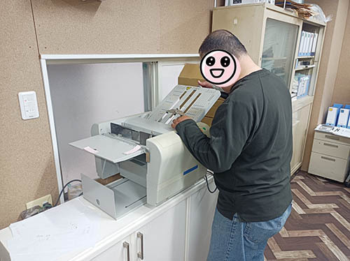 折り機で紙を折っているところ