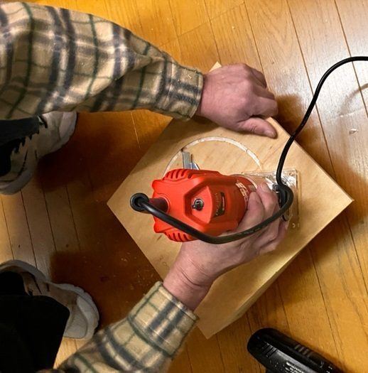 電動工具で板を丸く切り抜いているところ